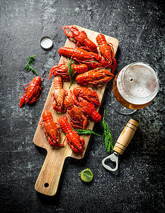 感蟹有礼红煮龙虾在有啤酒的切割板上深生背景背景