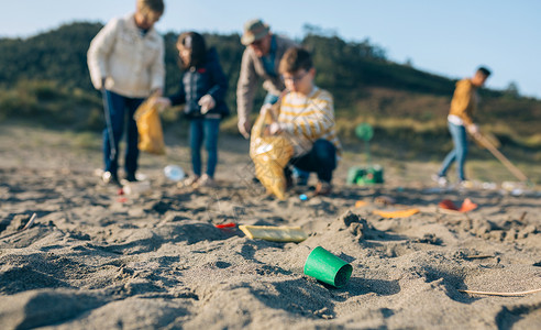 在海滩上捡垃圾的志愿者团体背景图片
