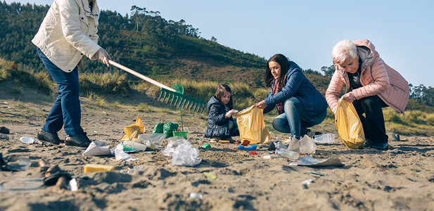 一群在海滩上捡垃圾的女志愿者背景图片