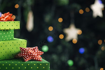 圣诞礼物包装在彩色品纸上圣诞树背景灯光亮度不高圣诞礼物图片