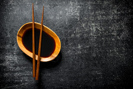 酱油在碗里有筷子深黑的生锈背景酱油在碗里有筷子图片