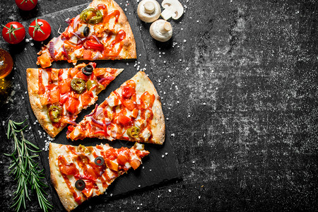 一块披萨一片墨西哥比萨饼加沙拉米和西红柿深黑的生锈背景一块墨西哥比萨饼加沙拉米和西红柿背景