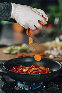 素食餐厅烹饪切成胡萝卜将切成煎锅运动模糊图片