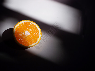 在夜光和影子下地板上切半满文橙色美丽的纸浆图片