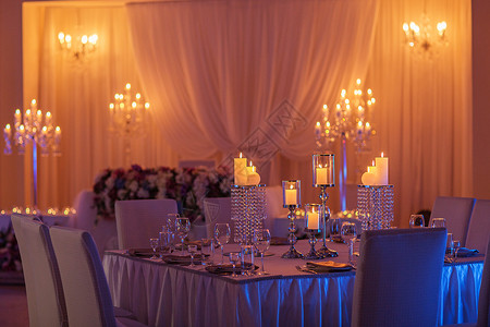 喜庆式婚礼桌用黄色灯光燃烧蜡烛水晶板块和眼镜水晶蜡烛架作为婚礼招待会的中心部分喜庆式婚礼桌作为招待会的中心部分背景图片
