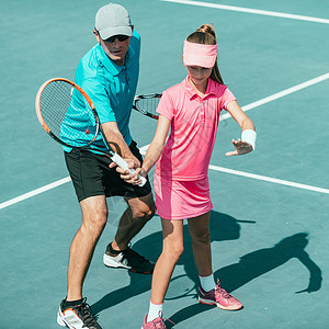 网球训练中与年轻女孩一起参加网球训练的教官背景图片