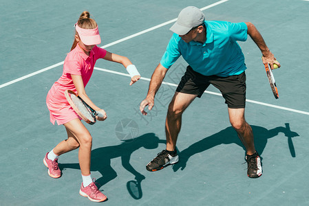 网球训练中与年轻女孩一起参加网球训练的教官背景图片