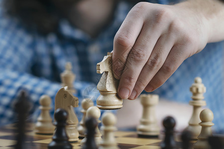 手握白骑士象棋和玩游戏制定赢取和成功的策略象棋手的移动片背景图片