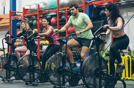 在体育馆骑空中自行车的运动员团体高清图片