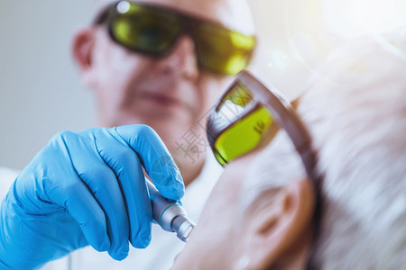 使用安全护目镜的牙医使用激光刷高级科护理背景图片