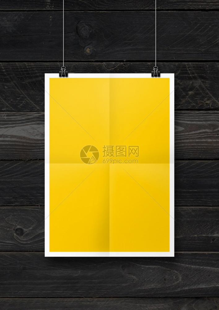 挂在黑色木墙上有剪片的黄色折叠海报空白模型板挂在黑色木墙上有剪片的黄色折叠海报图片