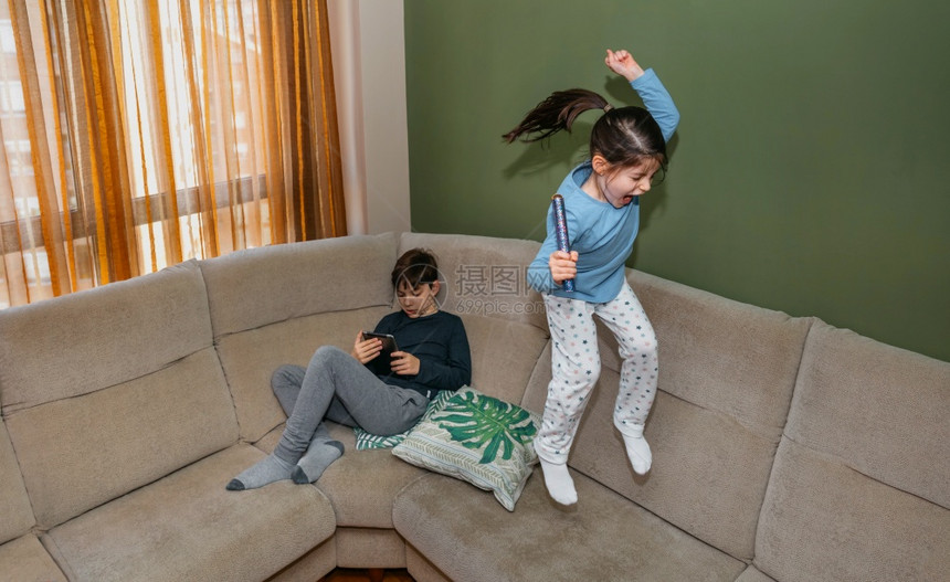 小女孩在沙发上跳着玩图片