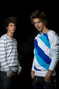 两名青年男子站在黑色背景下图片