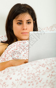 在床上用笔记本电脑工作的年轻女子眼睛高清图片素材