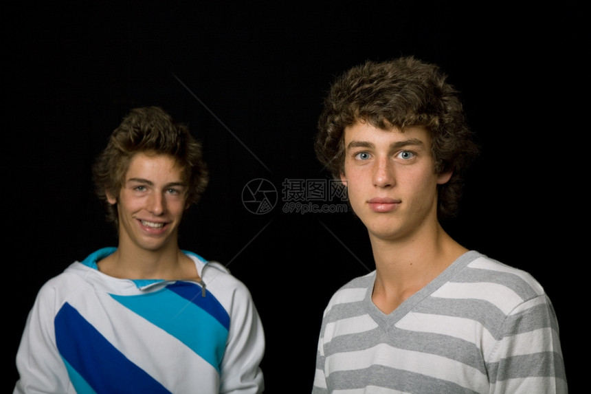 两名青年男子站在黑色背景的下图片