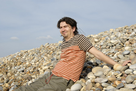 海滩石头边的青年临时工图片
