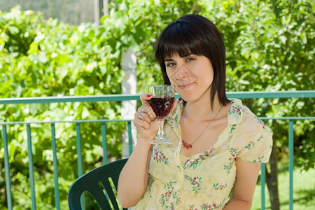 女人在户外葡萄园喝红酒背景图片