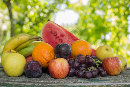 一堆西瓜葡萄户外木制桌边水果背景