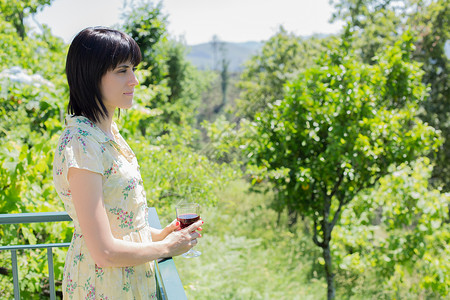 女人在户外葡萄园喝红酒背景图片