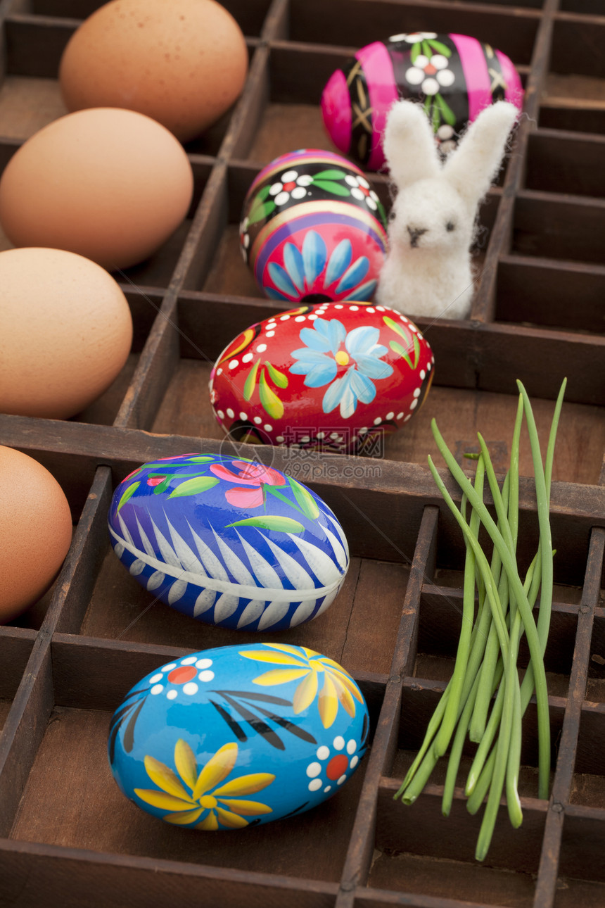 复活节装饰概念棕色鸡蛋用花粉绿色小鸡和羊毛兔子在旧式抽屉影子箱涂彩蛋图片