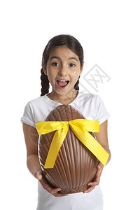 女孩带着一个大巧克力以为东蛋白色背景的彩蛋垂直的高清图片素材