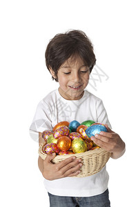 小男孩带着一篮巧克力复活节鸡蛋白色高清图片素材