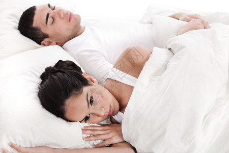 在床上睡觉的男人和失望躺着的女人图片