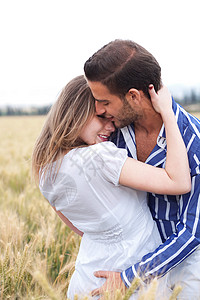 在公园里拥抱和亲吻彼此的年轻情侣肖像图片