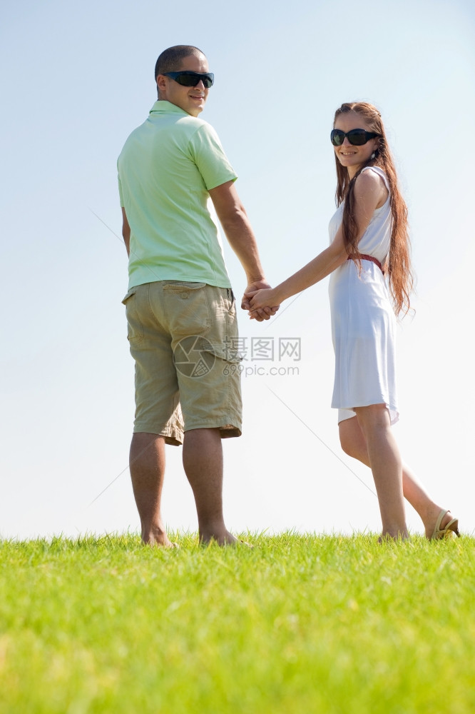 快乐的年轻夫妇在公园散步图片