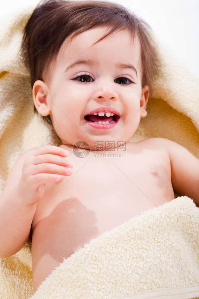 一个幸福的婴儿肖像包裹在黄毛巾里孤立的背景图片