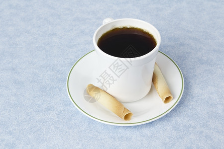 蓝桌布上配有茶碟杯子和饮料的咖啡图片