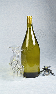 在未开瓶的子中用两个酒杯和蓝桌布上的软木螺丝图片