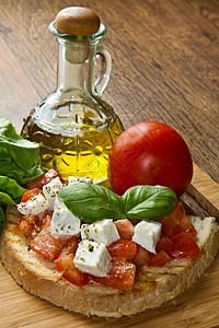 草本双年意大利布鲁夏塔配有新鲜西红柿面包大蒜橄榄油和奶酪背景