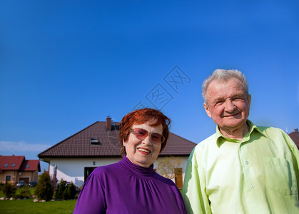 老年夫妻在新房子前微笑图片