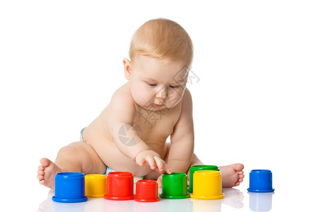 婴儿玩杯具孤立于白种背景图片