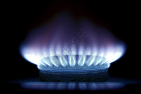 黑暗中煤气炉灶的蓝色火焰背景图片