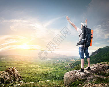带背包的旅游者享受山顶的谷风景傍晚高清图片素材
