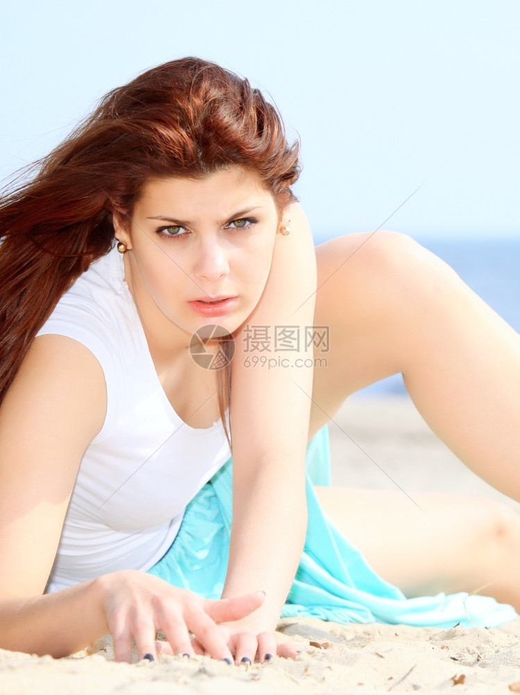 在海滩上享受暑假的年轻妇女图片