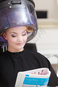 阅读沙龙年轻女客户在美发容院阅读杂志背景