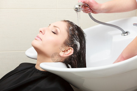 理发师洗客户头美容院的发女郎工作高清图片素材