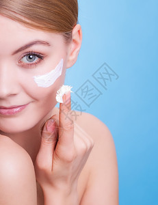 皮肤发红皮肤习惯年轻女面部是蓝色红毛皮的象征女孩用湿润的奶油照顾干燥皮肤美容治疗背景