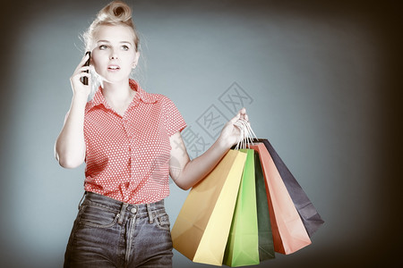 女顾客在灰色上拿着购物袋零售和销图片