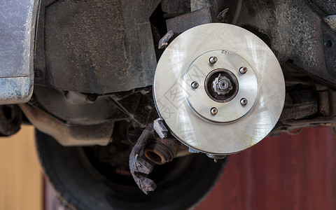 汽车更换被损坏轮胎过程中的汽车前磁盘刹汽轮式组装的特写图片
