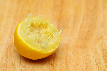 柠檬水果半压在旧木制餐桌厨房切菜背景上健康食品有机营养图片