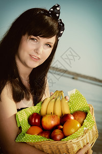野餐沙滩上有一篮子水果的女复古者背景图片