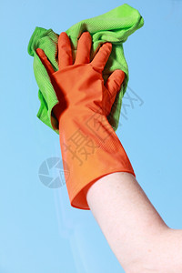 用绿色抹布橙手套清洗窗户背景图片