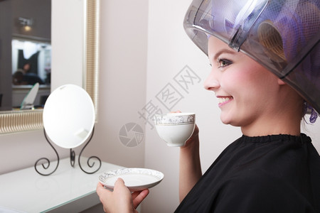 年轻女客户在美发容院喝热饮咖啡茶图片