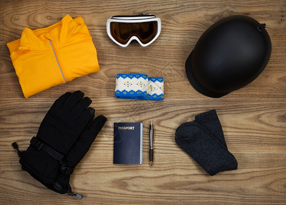 固定木板上基本滑雪和板配件的俯视图包括头盔护目镜手套汗衫头带羊毛袜和护照衬衫高清图片素材
