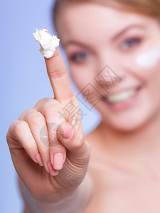 年轻漂亮的女孩照顾干燥的皮肤用湿润奶油美容治疗图片