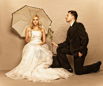 买满即送结婚日浪漫已夫妇金发新娘的肖像配着雨伞和美新郎的给女孩送玫瑰背景